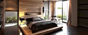 a bed with a wooden headboard and a lamp